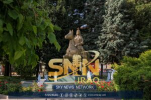 Equestrian statue in a vibrant park setting with fountains and lush greenery.