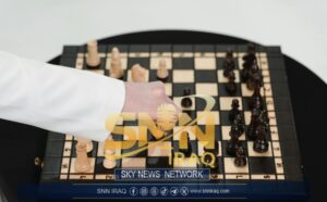 Close-up of a hand strategically moving a chess piece on a wooden chessboard.