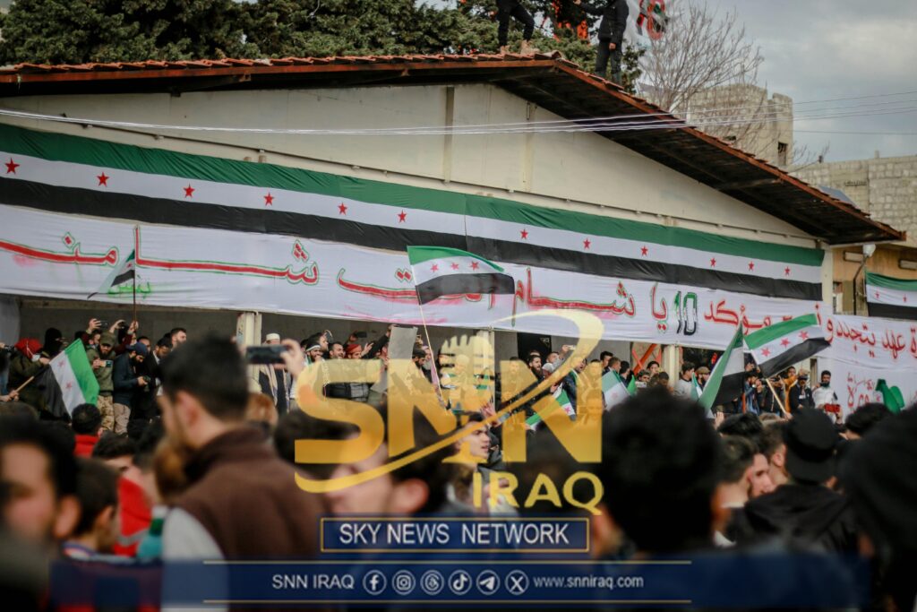 Protesters gather with Syrian flags in an Idlib street demonstration.