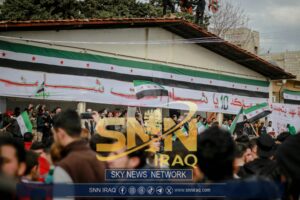 Protesters gather with Syrian flags in an Idlib street demonstration.