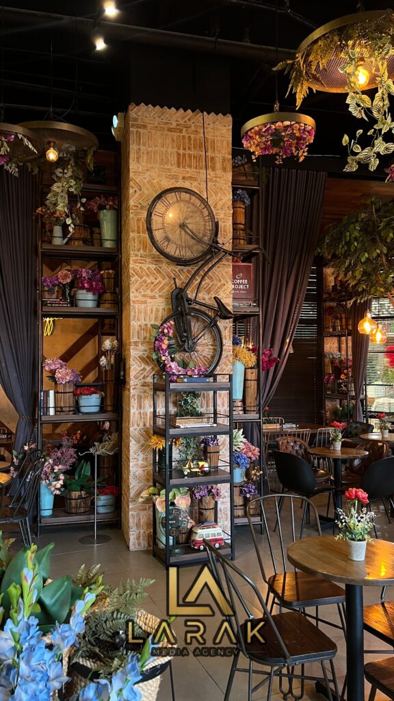 Charming cafe interior with floral decor, hanging plants, and bicycle wall art, creating a cozy atmosphere.