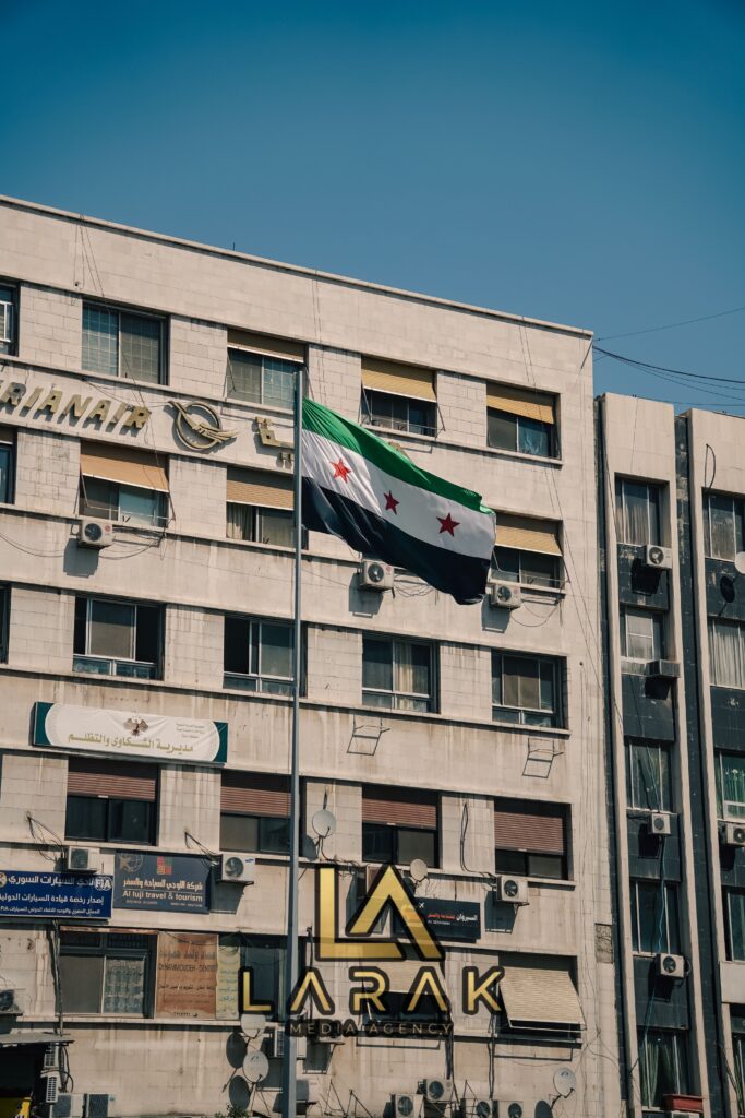 The Syrian flag waves on a historic building in Damascus, capturing the essence of the city's architecture and culture.